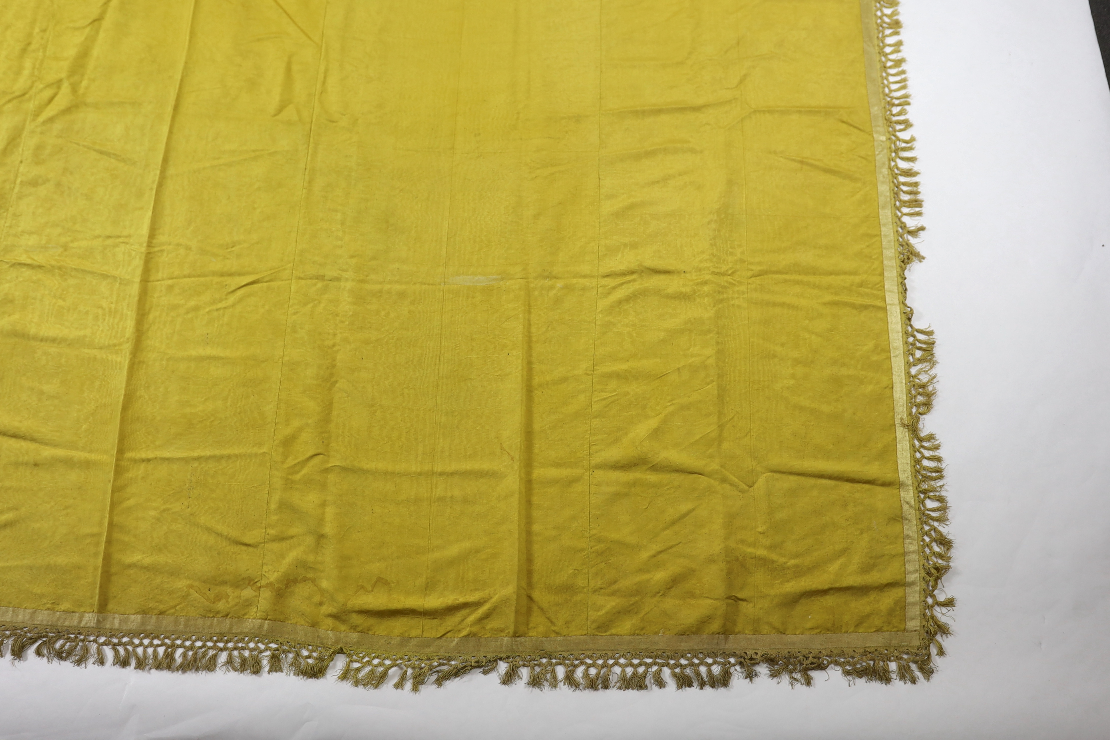 A large Regency yellow silk curtain, with fringed base, French short loom ribbed silk panels made into a wide curtain, with fringing on each side and at the bottom, 9ft wide x 8ft 6in. long